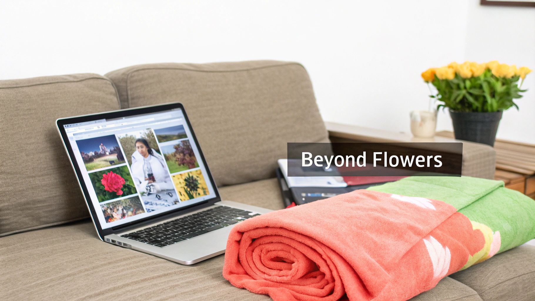 A cozy living room scene with a laptop displaying a photo collage, blankets, and yellow flowers on a sofa.