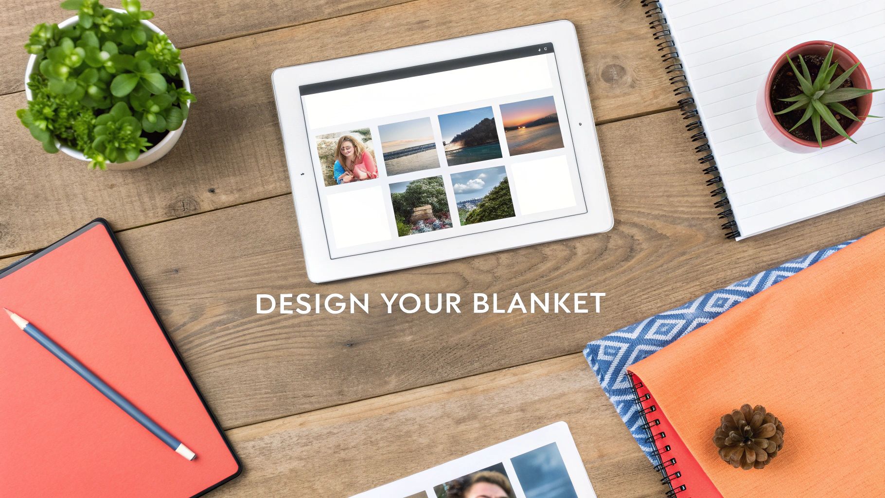 Overhead shot of a tablet displaying photos for blanket design, surrounded by desk items on wood.