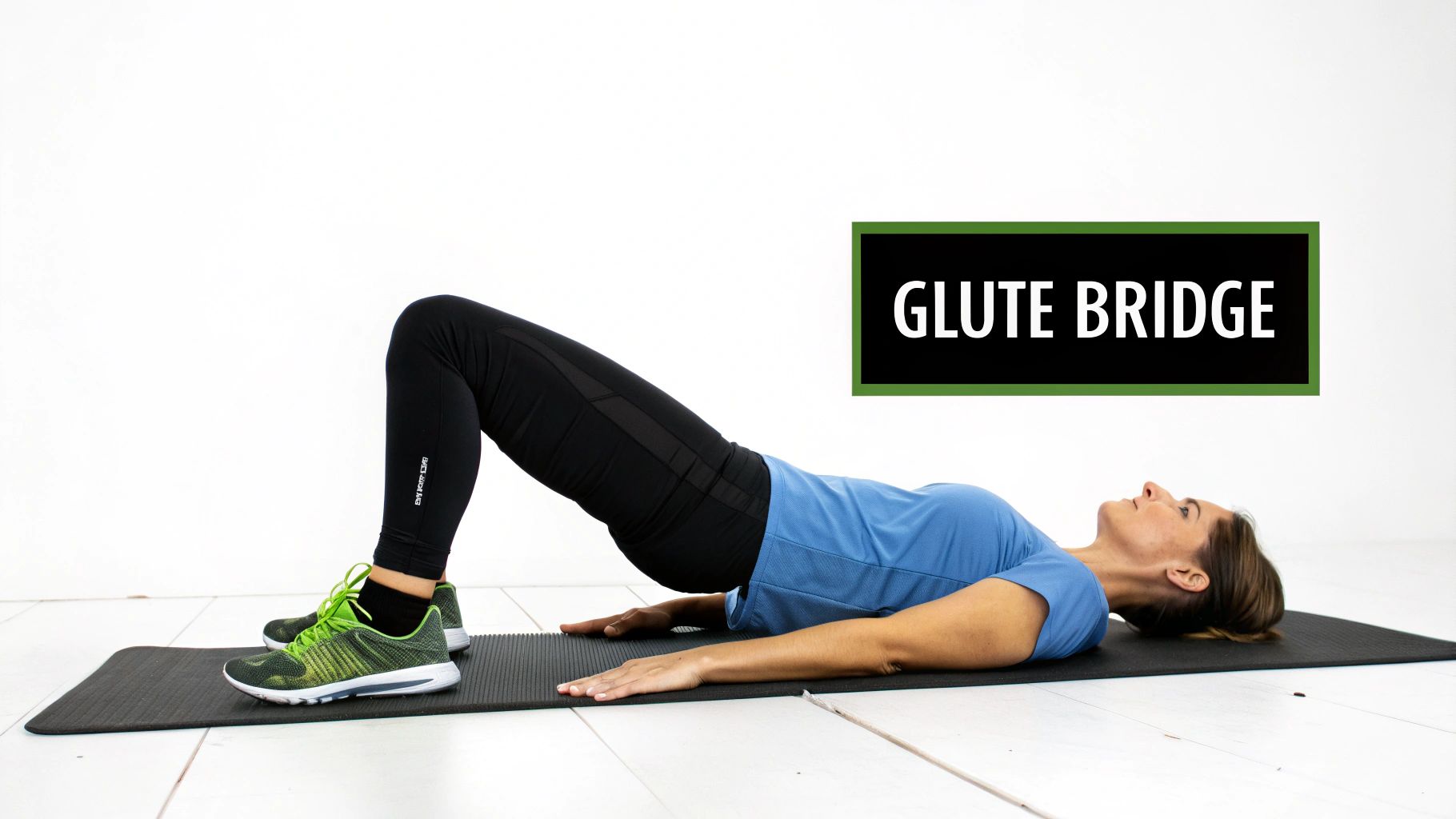 Side view of a woman performing a glute bridge exercise on a black mat.