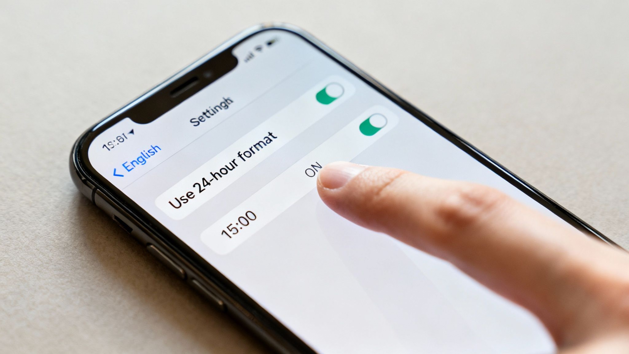Close-up of a phone screen displaying 'Use 24-hour format' setting turned ON.