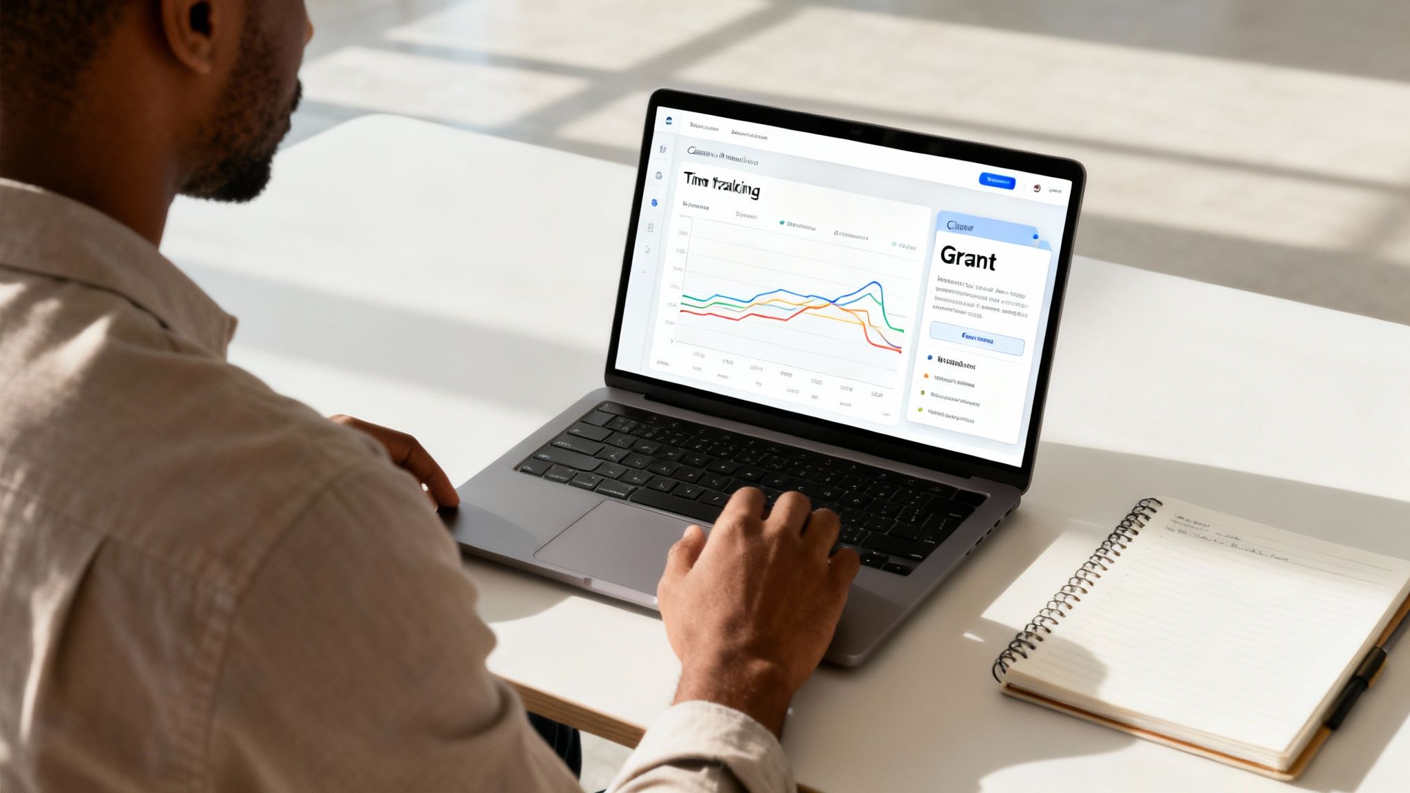 A person from behind, working on a laptop displaying a time tracking dashboard with graphs.