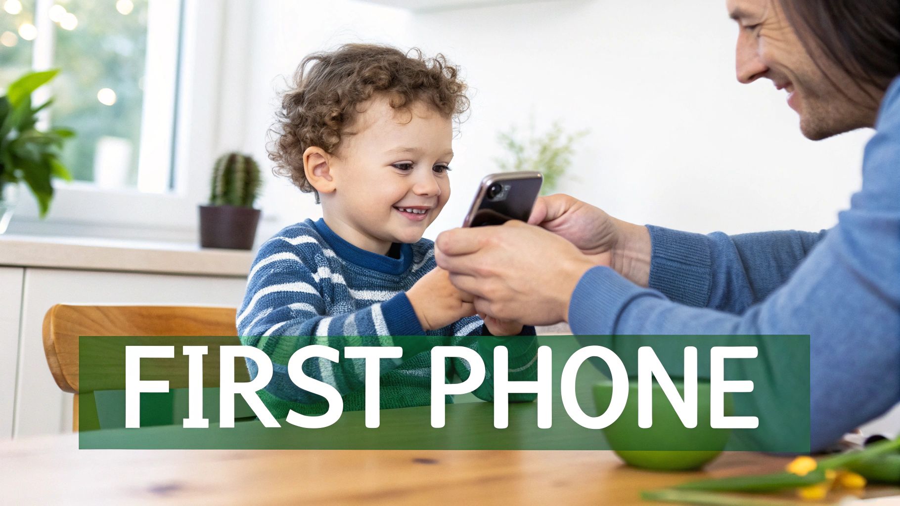 A smiling child with curly hair looks eagerly at a smartphone held by an adult.
