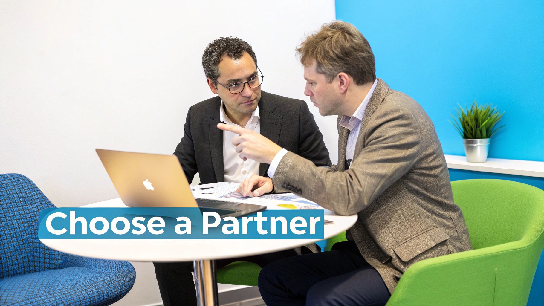 Two businessmen discussing strategy and pointing at documents on a table with a laptop.