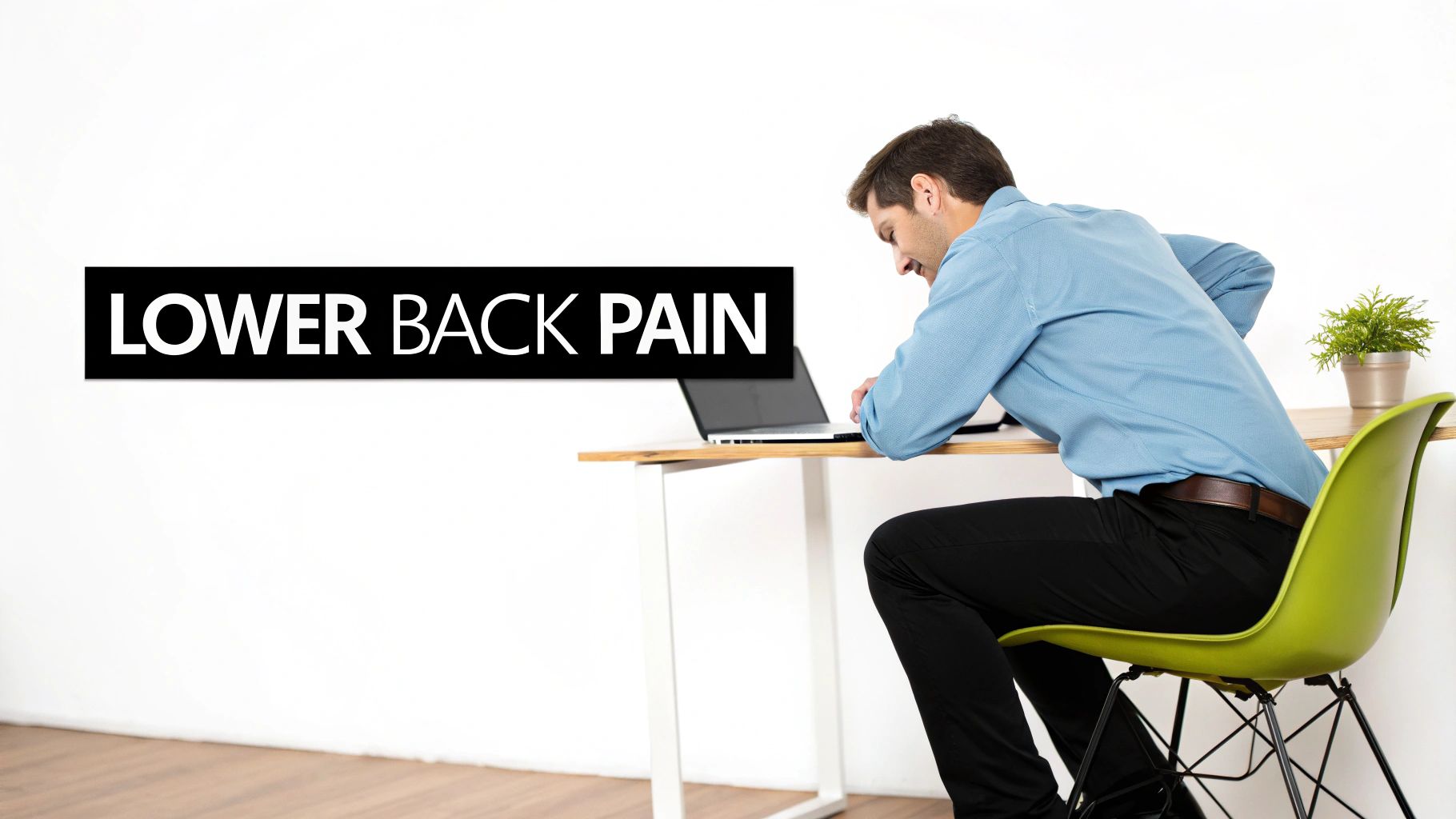 A man experiencing lower back pain while sitting at a desk with a laptop.