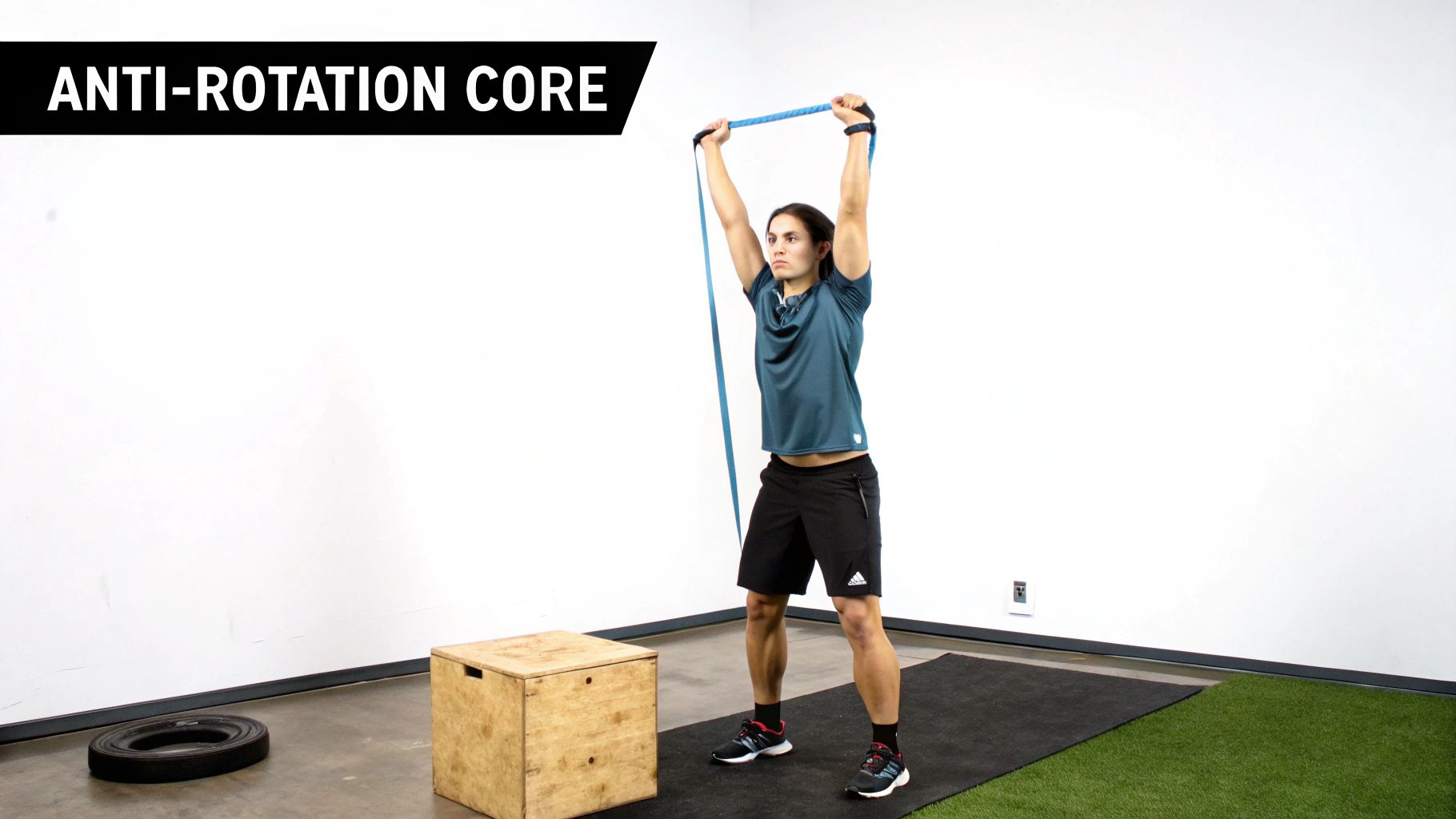 A person performs an anti-rotation core exercise with a resistance band held overhead in a gym.