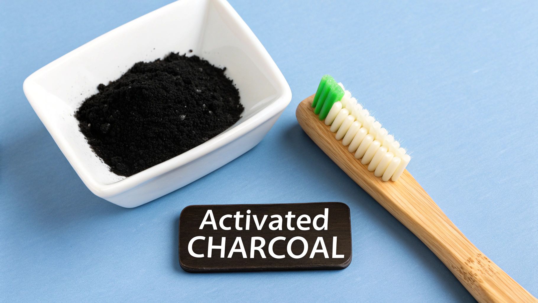 Activated charcoal powder in a bowl next to a bamboo toothbrush for natural teeth whitening.