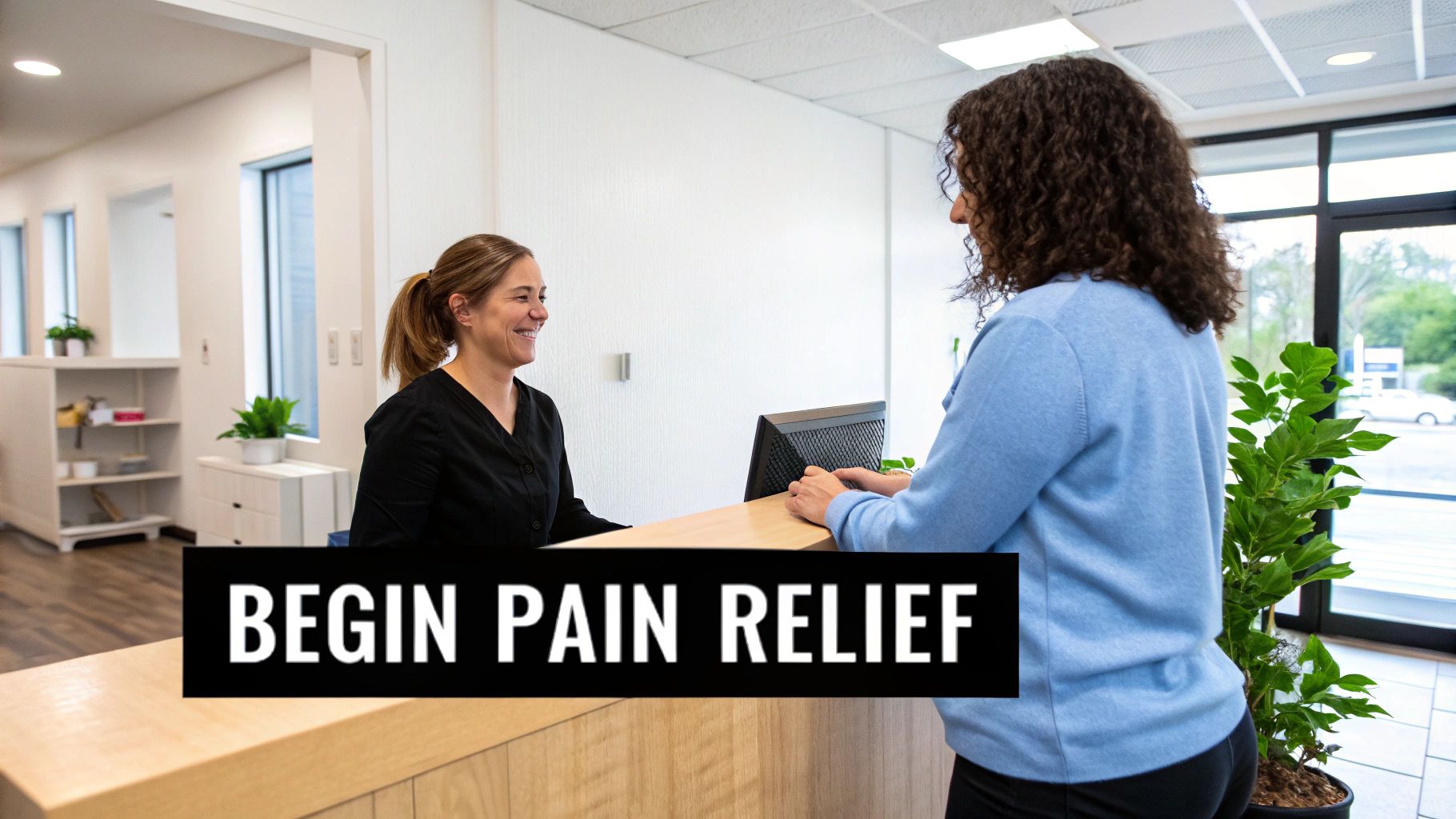 A friendly receptionist smiles at a patient checking in at a modern medical office front desk.