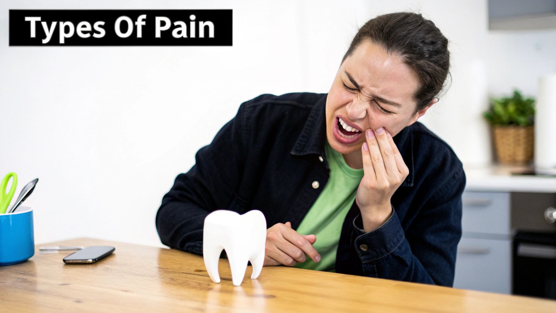 A distressed woman holds her jaw, indicating severe tooth pain, with a large tooth model on a table.