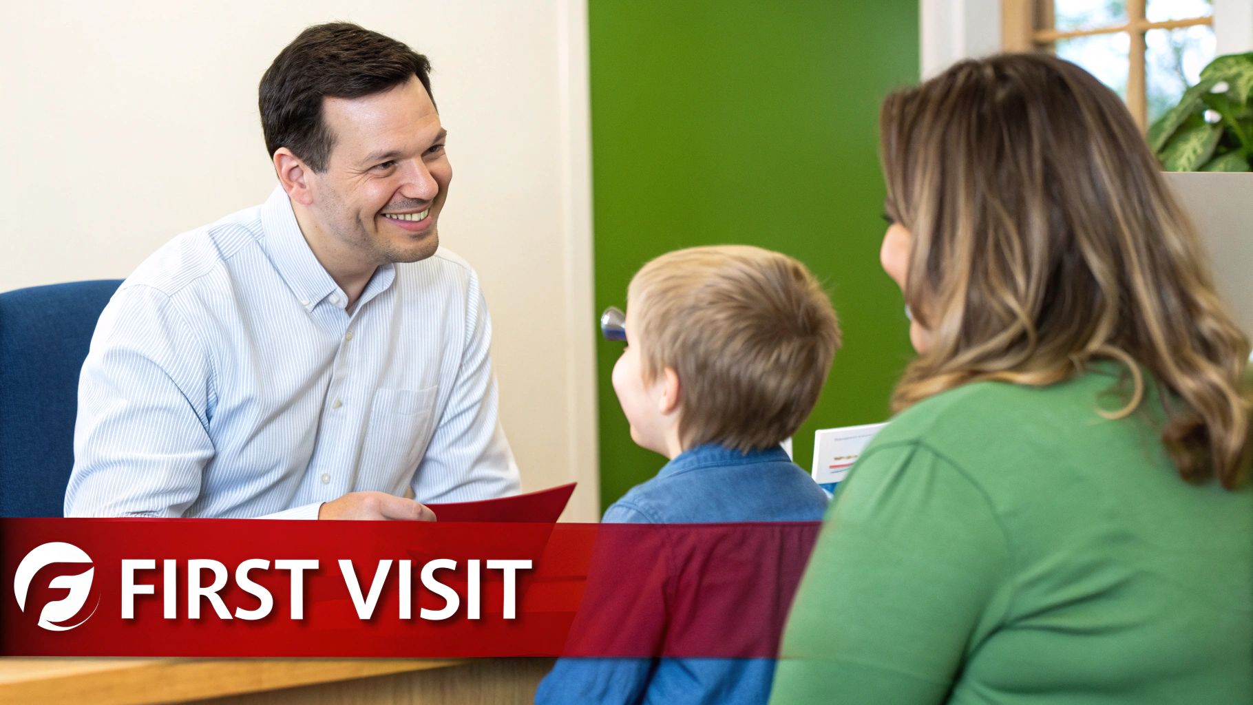 A friendly doctor smiles at a mother and her young son during their first visit at a clinic.