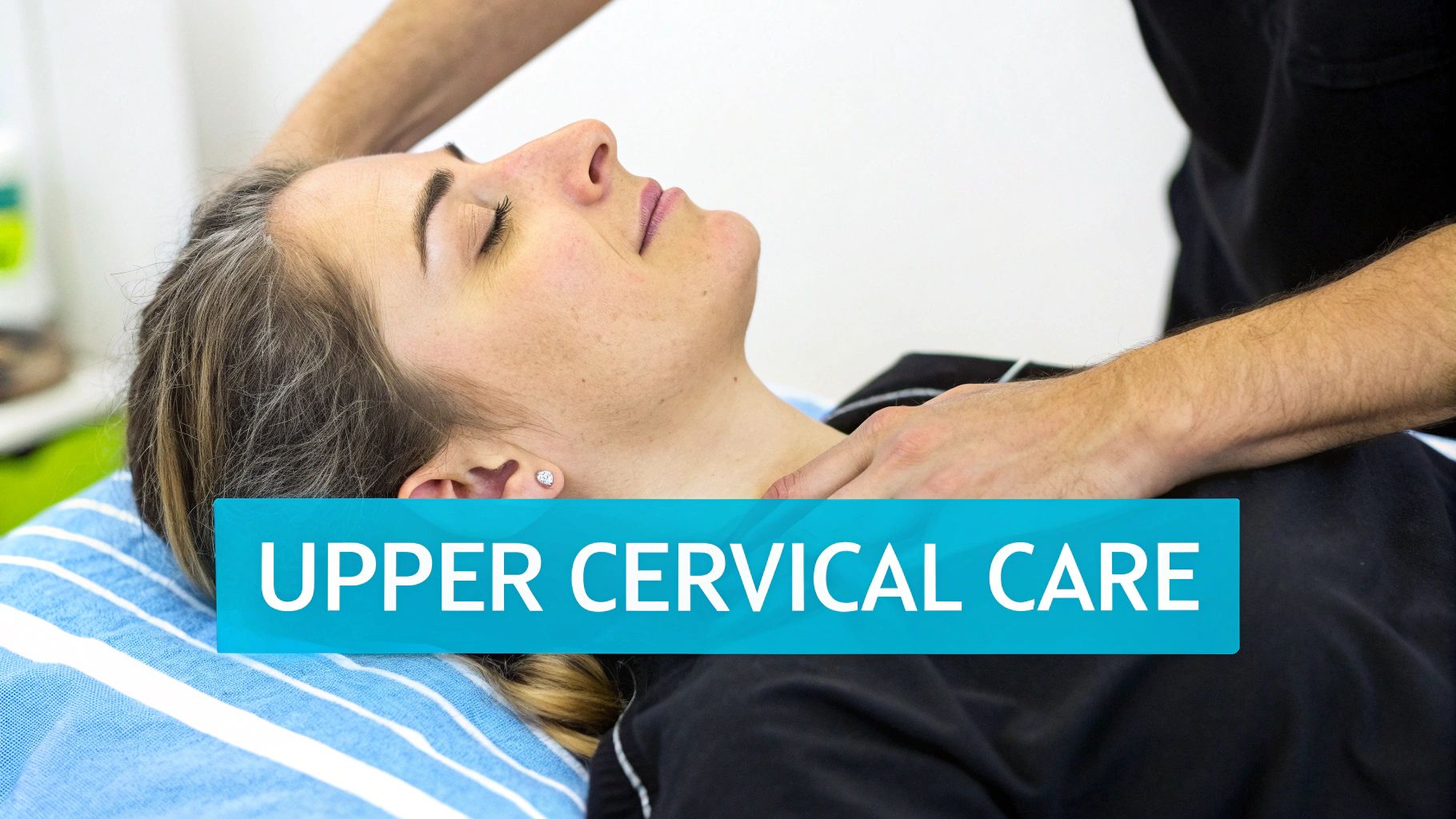 A woman receives upper cervical care from a practitioner, lying relaxed on a striped pillow.