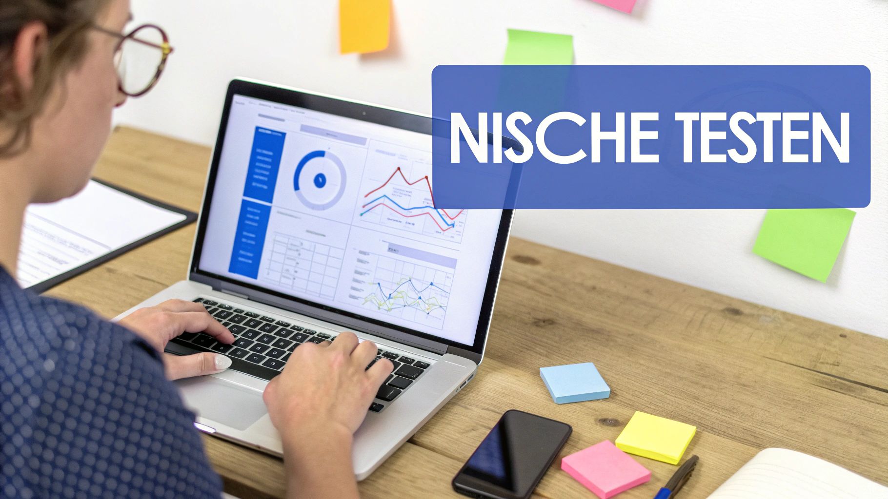 Person arbeitet an einem Laptop mit Datenanalysen und Diagrammen, während Notizen und ein Smartphone auf dem Holztisch liegen.