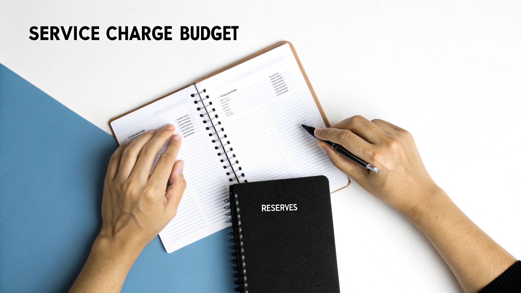 Hands reviewing an open budget notebook with a 'RESERVES' book, planning service charges and accounting.