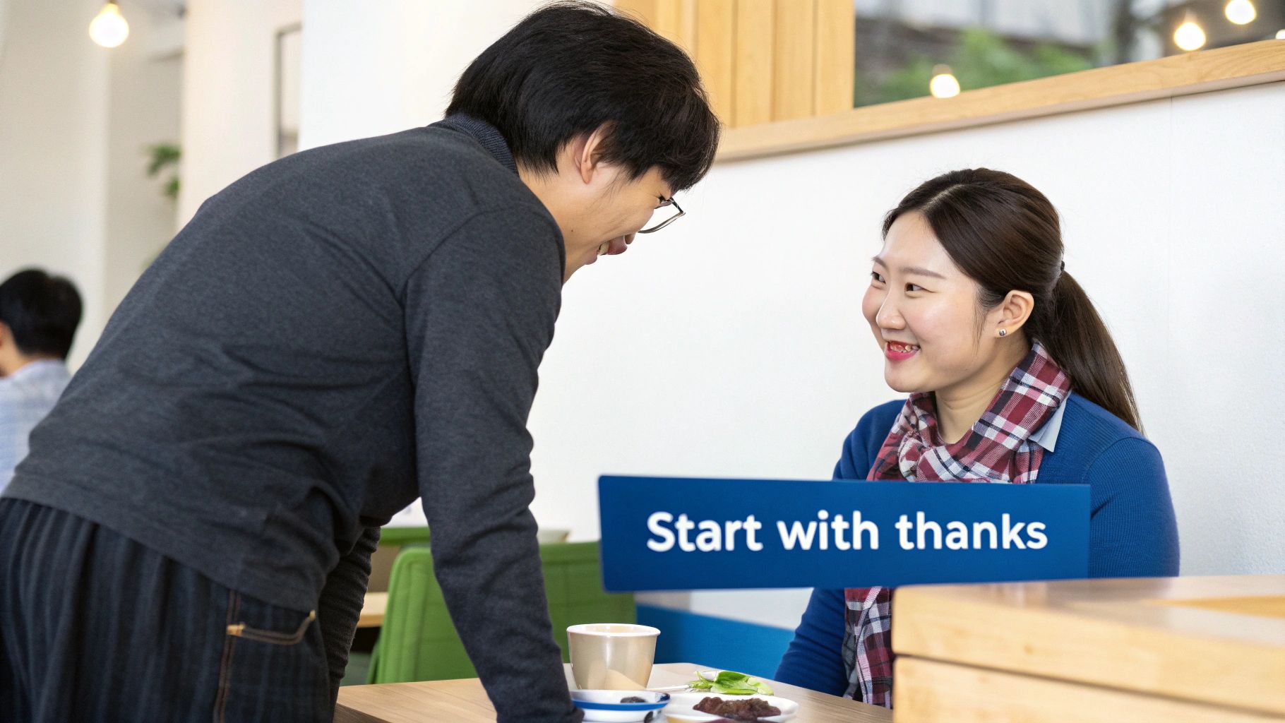 Two smiling Korean people, a man and a woman, talk cheerfully at a table with a 'Start with thanks' sign.