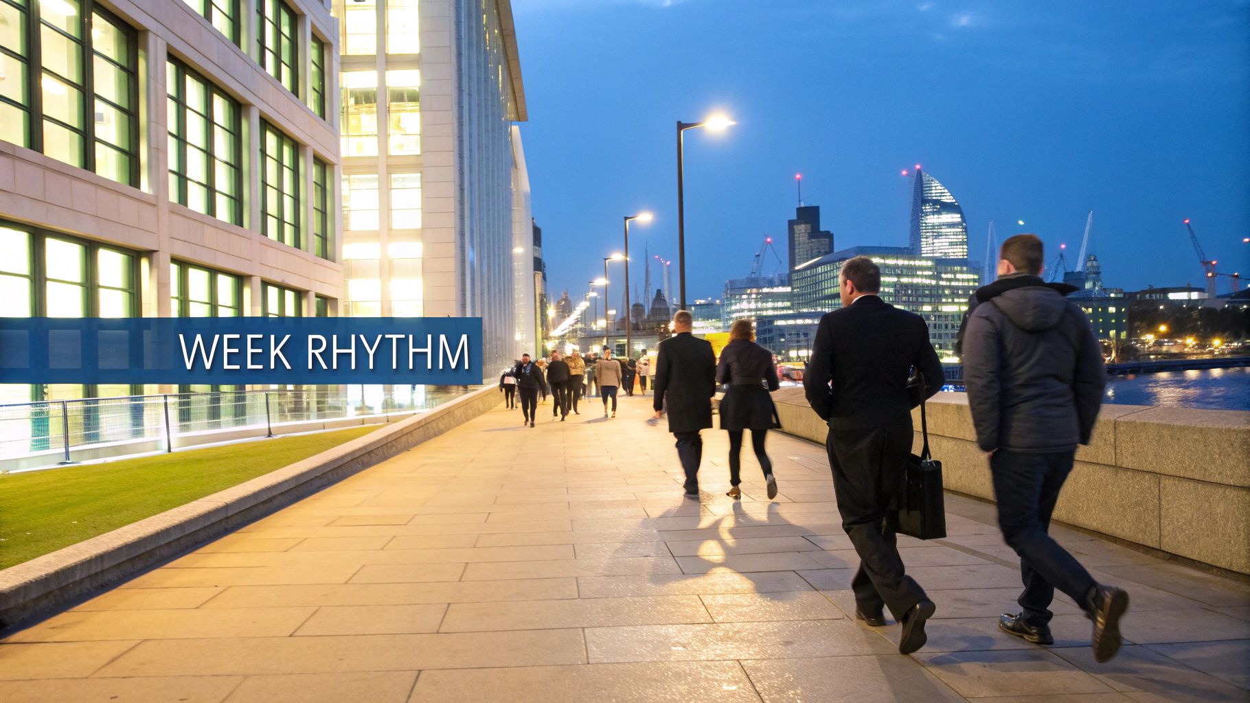 Urban scene at dusk with commuters walking past illuminated buildings and a city skyline.