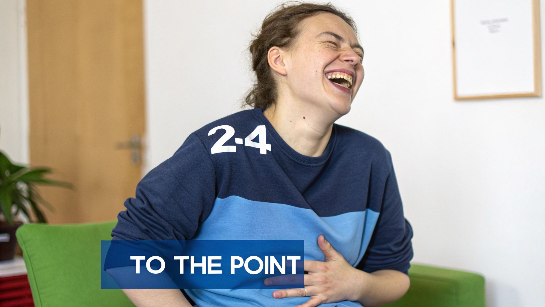 A woman in a blue shirt is laughing joyfully with her eyes closed, holding her stomach.