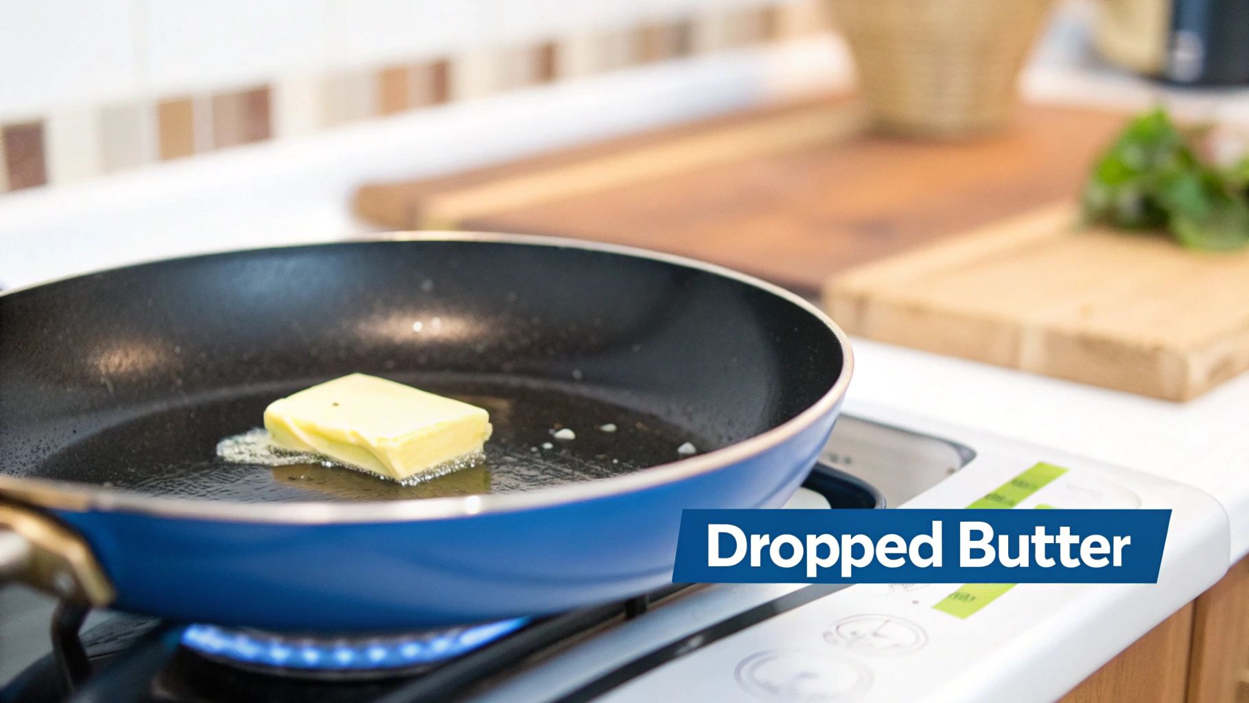 A pat of butter is melting in a blue frying pan on a gas stove burner with a blue flame.