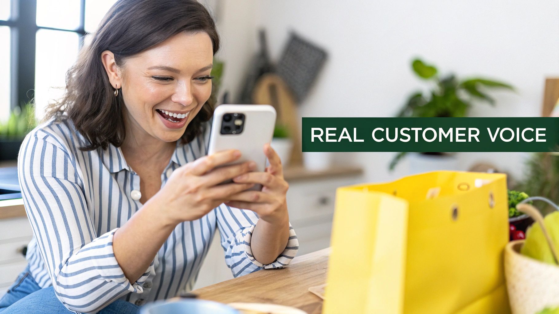 A happy woman smiles while looking at her phone next to a bright yellow shopping bag, representing customer voice.