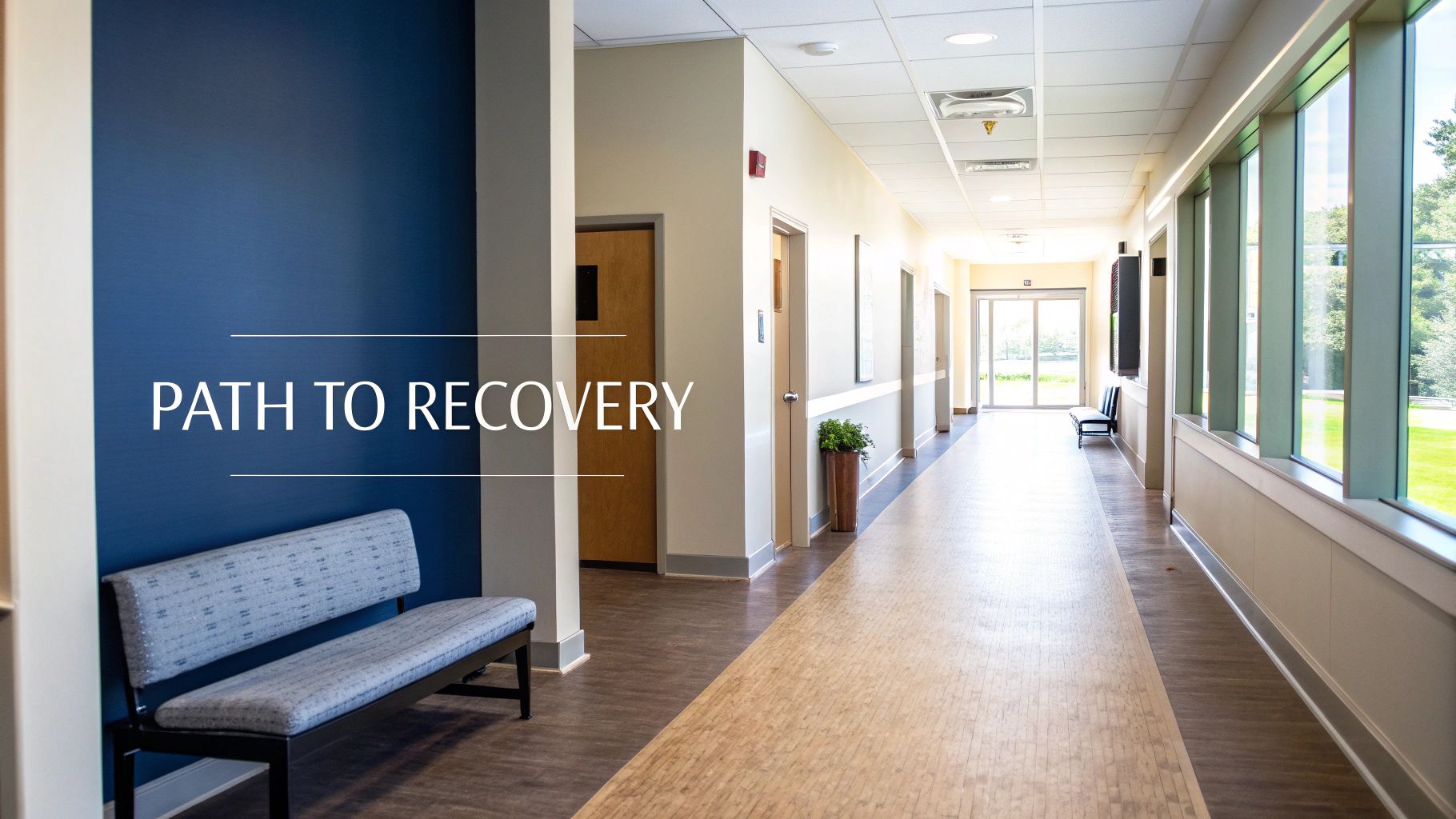 A bright, empty hallway in a medical facility with "PATH TO RECOVERY" text and large windows.