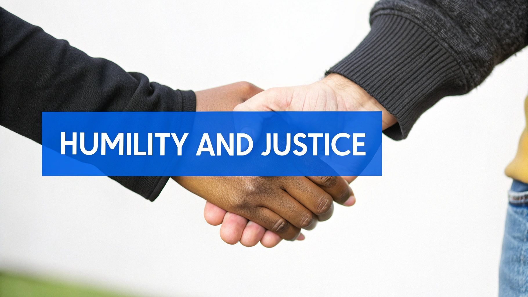 Two people shaking hands outdoors, symbolizing reconciliation and mending relationships.