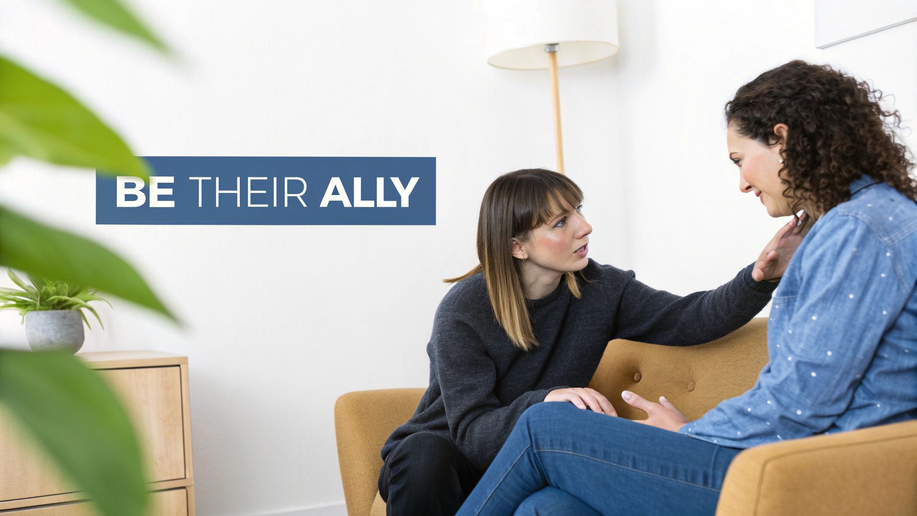 Two women on a couch, one comforting the other, with text 'BE THEIR ALLY'.