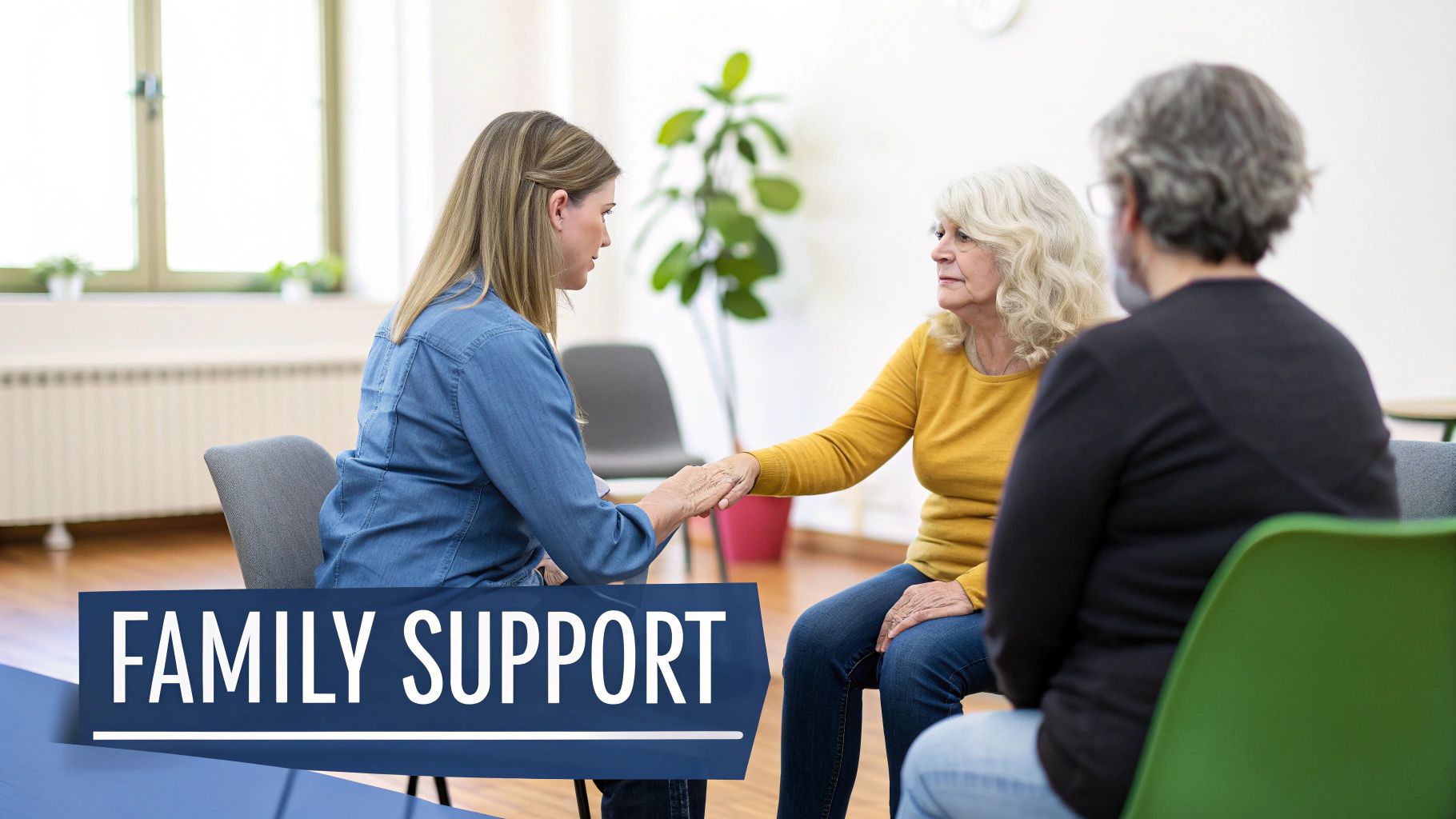 Two women holding hands during a family support group session, offering comfort and understanding.
