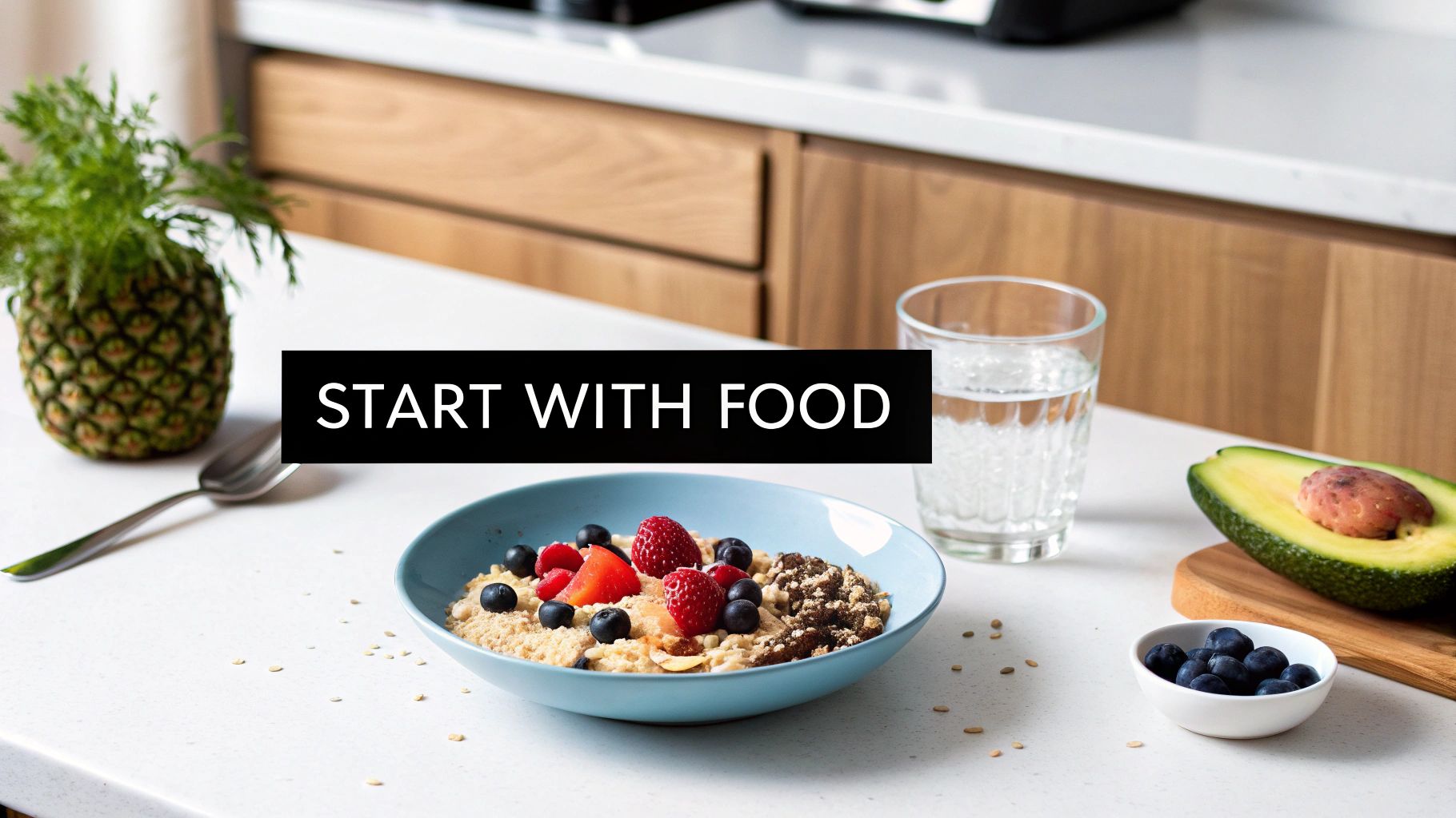 A healthy breakfast with a bowl of oatmeal, fresh berries, avocado, water, and a pineapple.