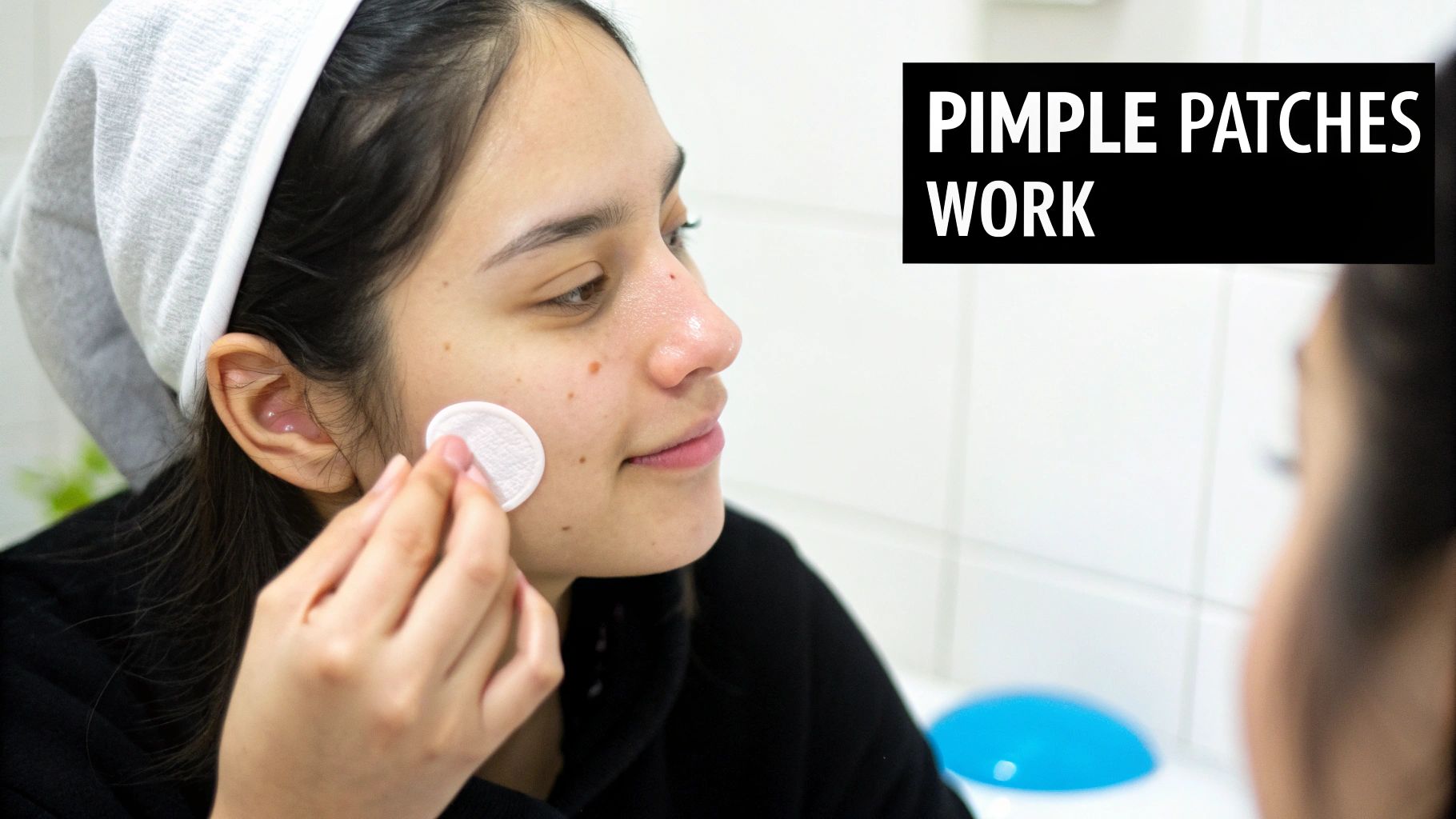 A person applying a pimple patch to their cheek.