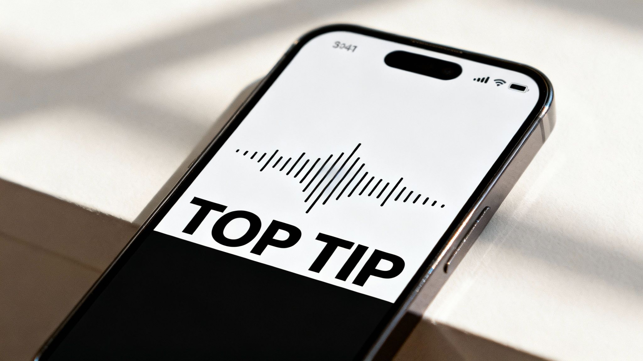 Close-up of a smartphone displaying 'TOP TIP' text and a sound wave graphic on its screen.