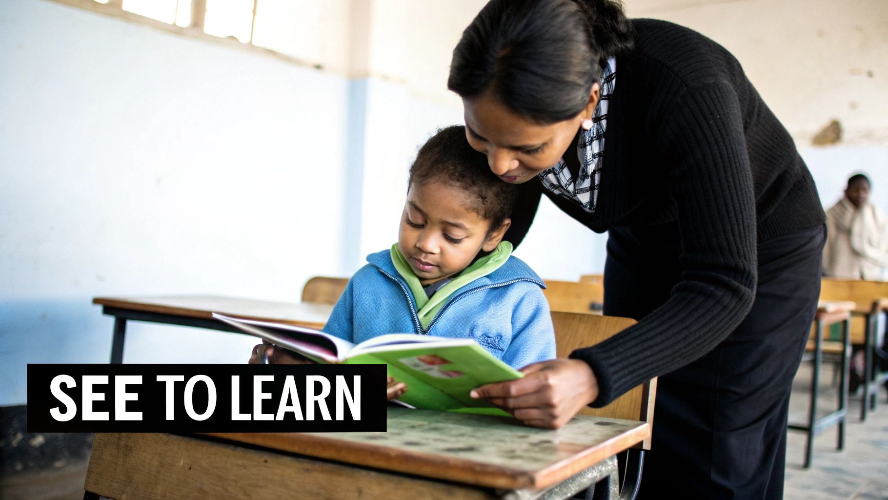 A teacher helps a young student read a book, emphasizing the importance of clear vision for learning.