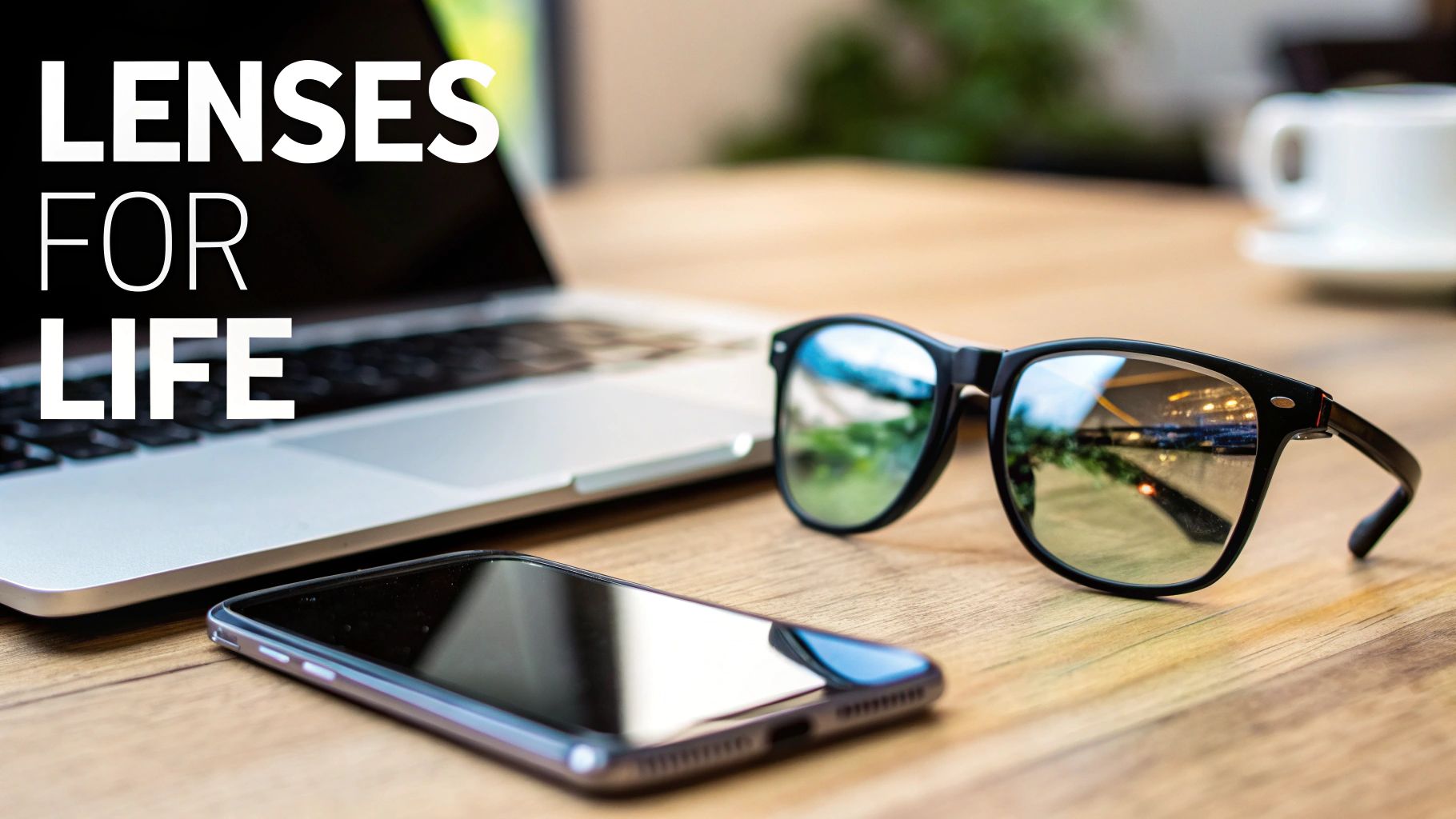 Black rectangle sunglasses, smartphone, and laptop on a wooden table with 'LENSES FOR LIFE' text.
