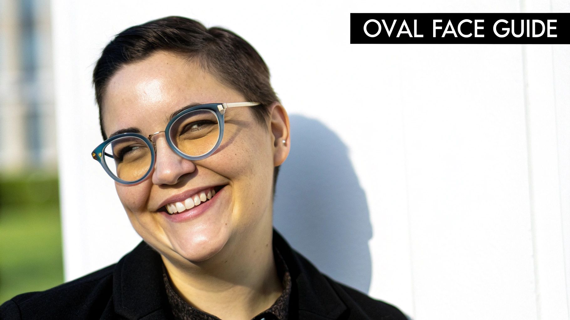 A person with an oval face smiling and wearing stylish rectangular glasses that complement their features.