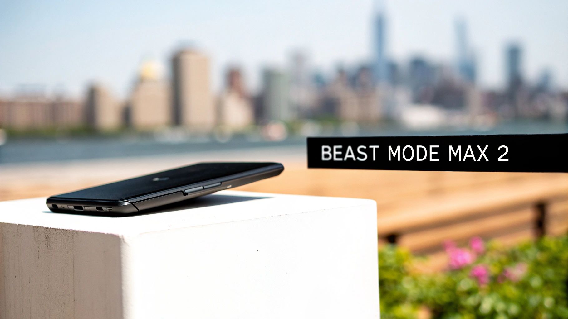 A black smartphone on a a white block, with a 'BEAST MODE MAX 2' sign and a city skyline.