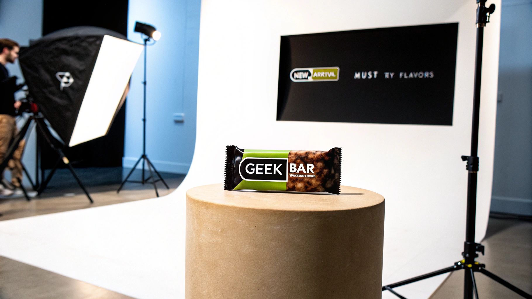 A 'GEEK BAR' on a wooden pedestal in a professional photo studio setup with lighting equipment.