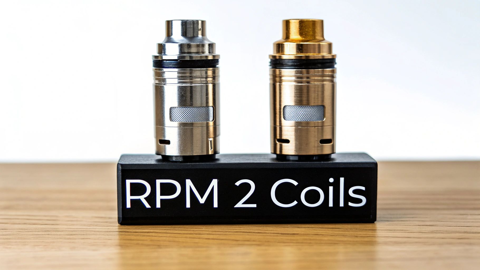 Two stylish silver and gold RPM 2 vape coils displayed on a black stand.