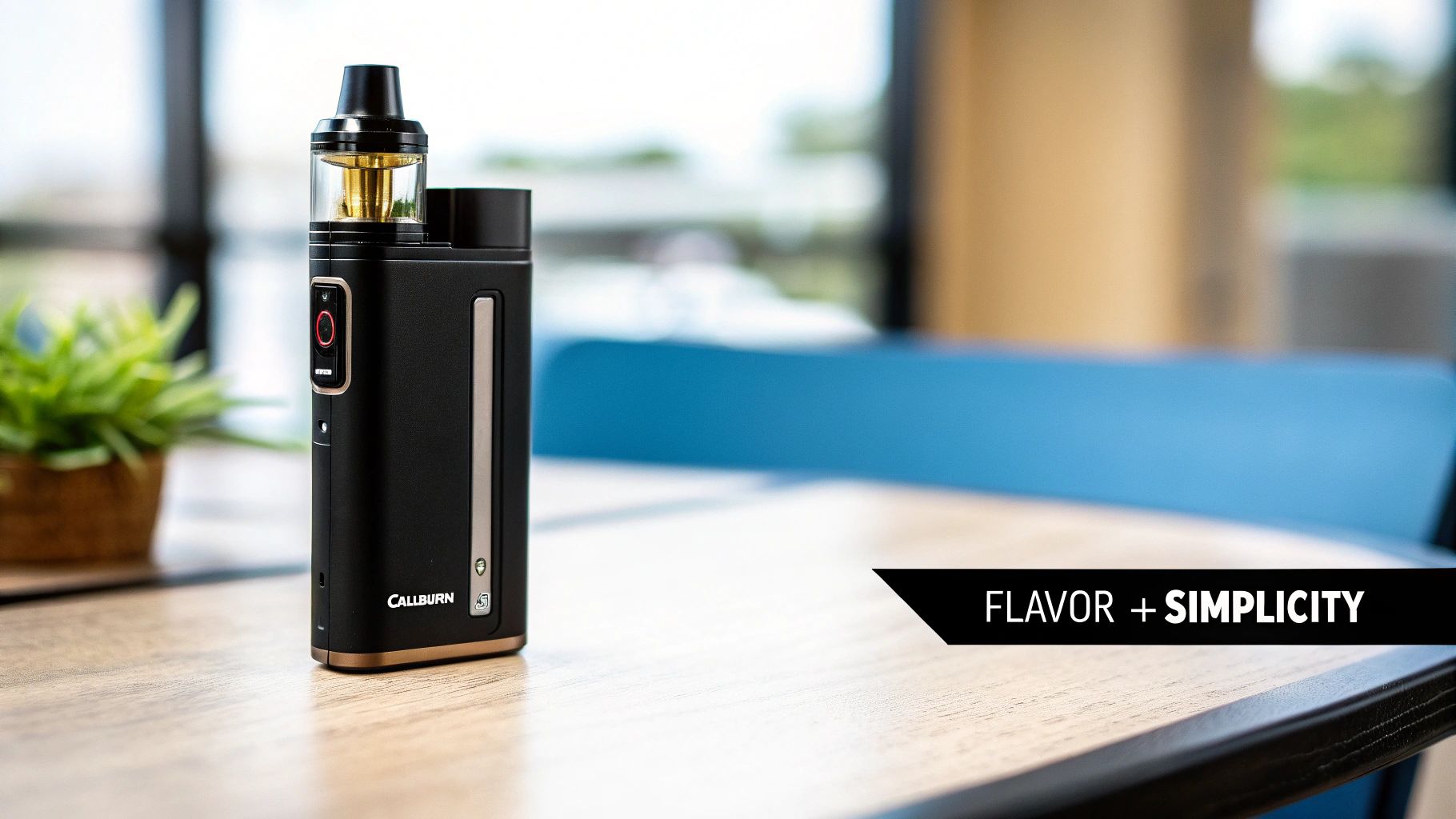 Black and gold Caliburn vape device with clear pod on a wooden table.
