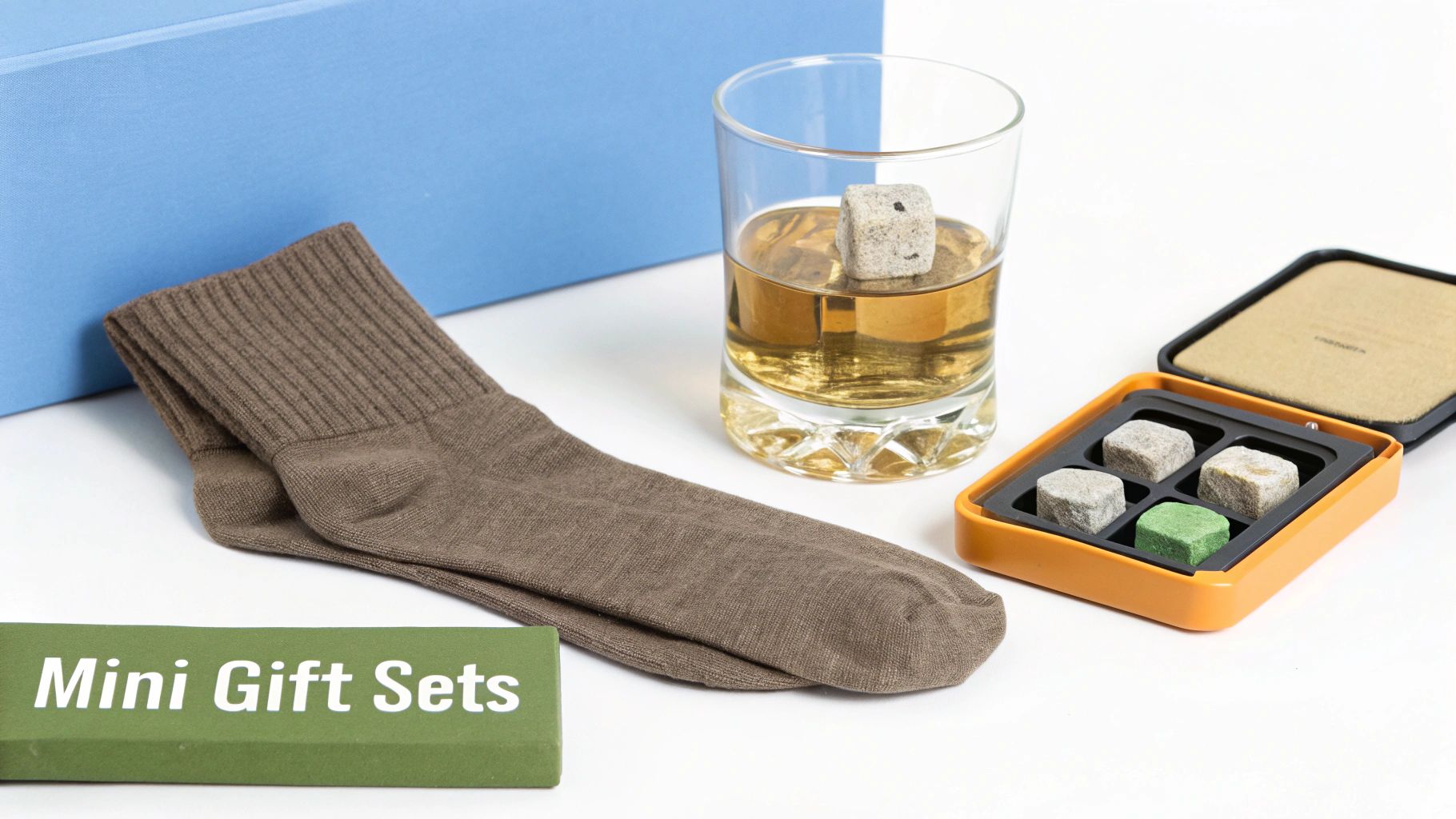 A pair of brown socks, a whiskey glass with a stone, and a gift set of whiskey stones.