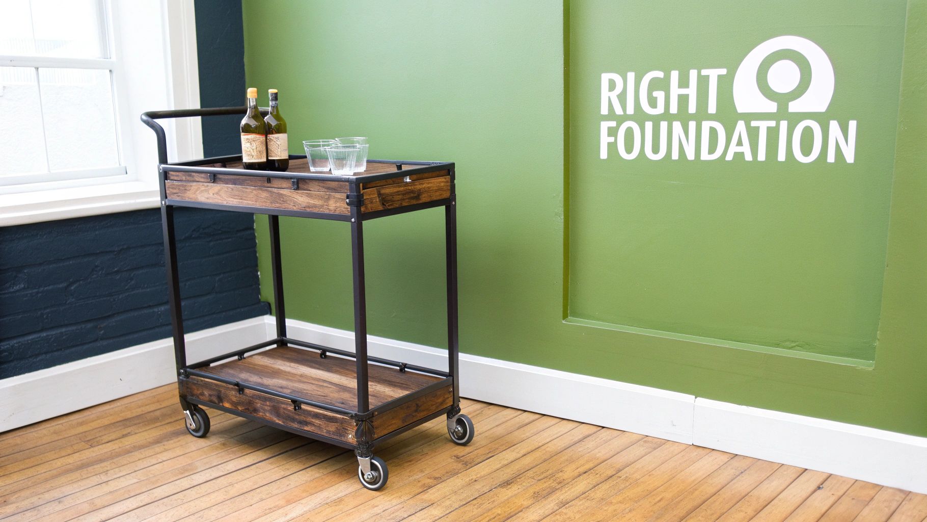 A stylish gold bar bar cart organized with glasses, spirits, and decorative plants.