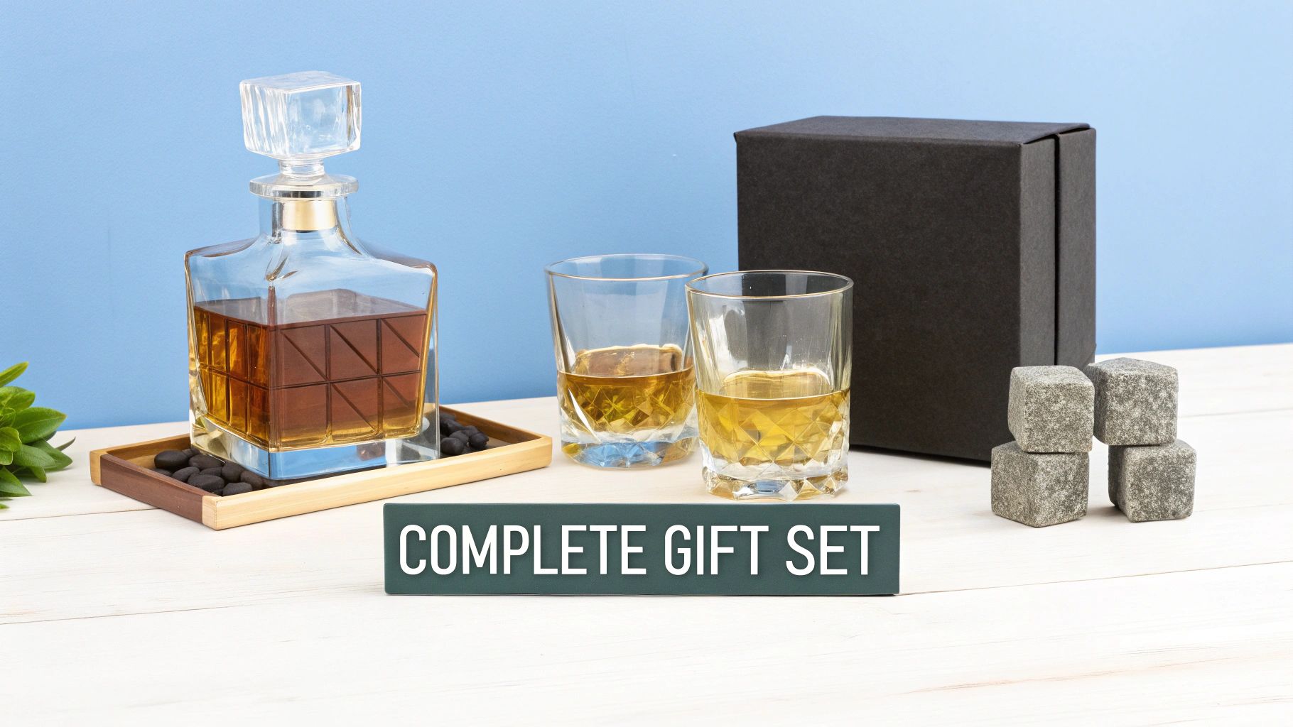 A luxurious whiskey gift set featuring a decanter, two glasses, chilling stones, and a black gift box.