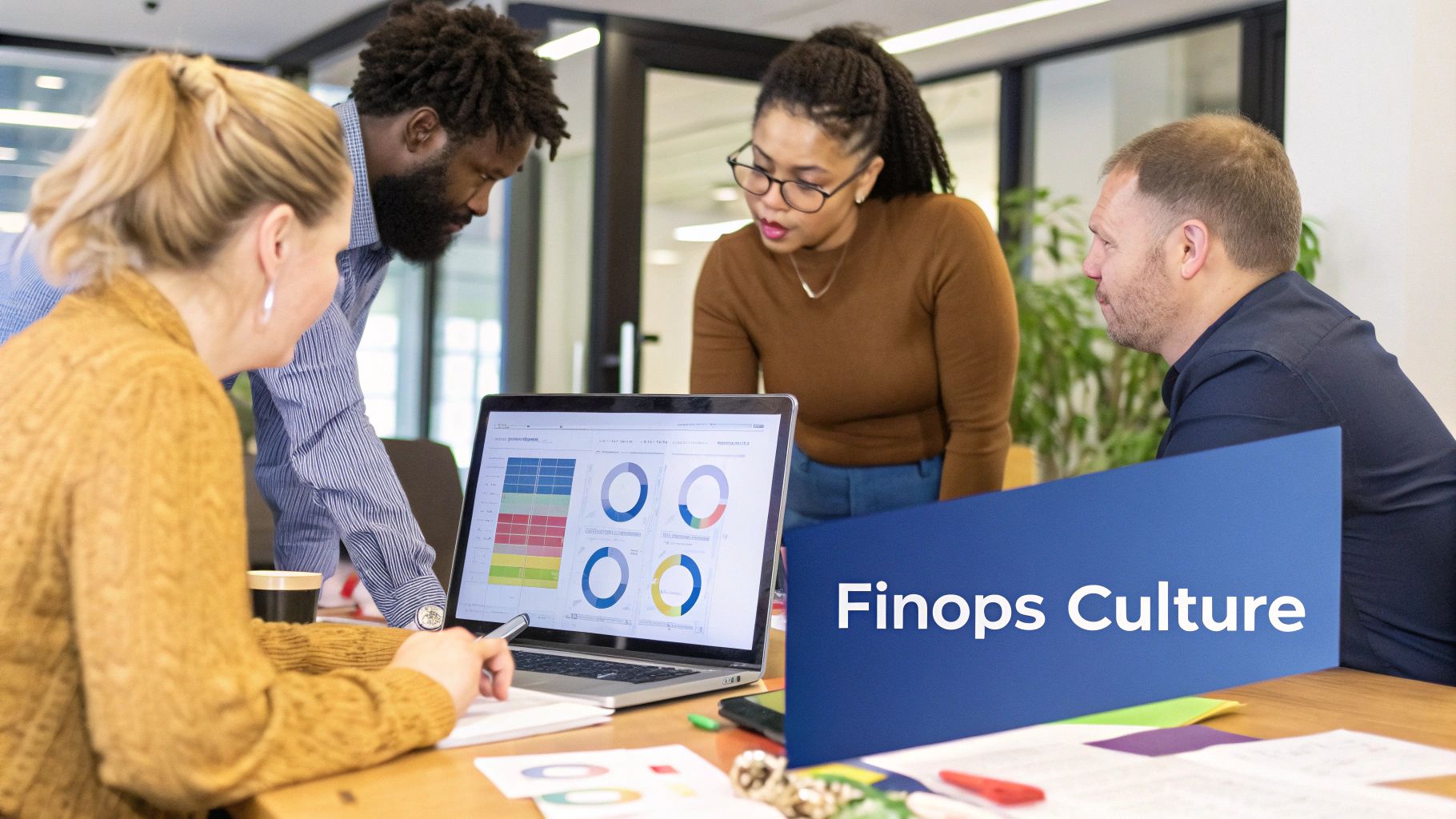 A diverse team collaborates around a table with charts and graphs, representing a FinOps culture.