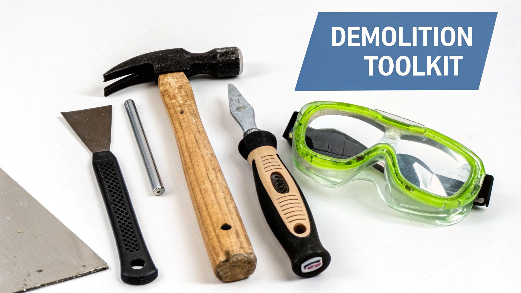 A collection of demolition tools including a hammer, scraper, punch, prying tool, and safety goggles.