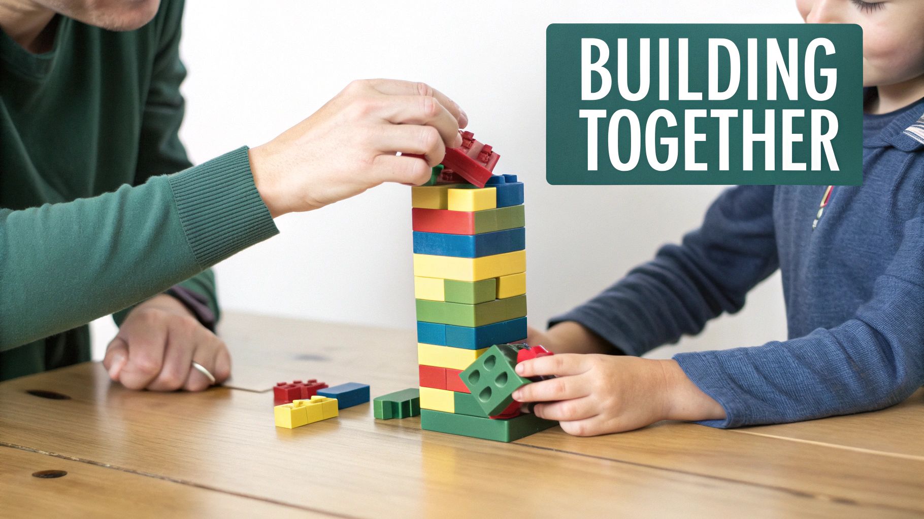 A parent and child playing together on the floor, deeply engaged with colourful building blocks.