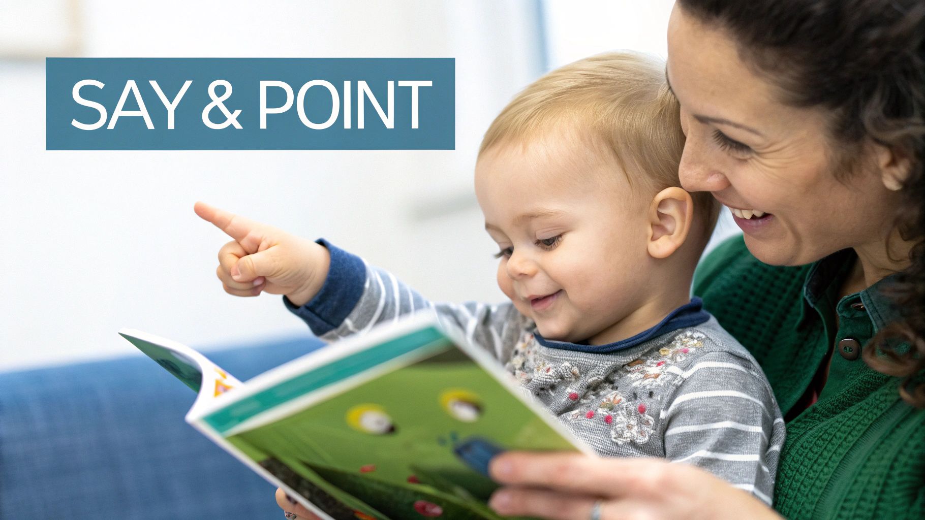 A joyful mother and baby reading a book together, the baby points at a page.