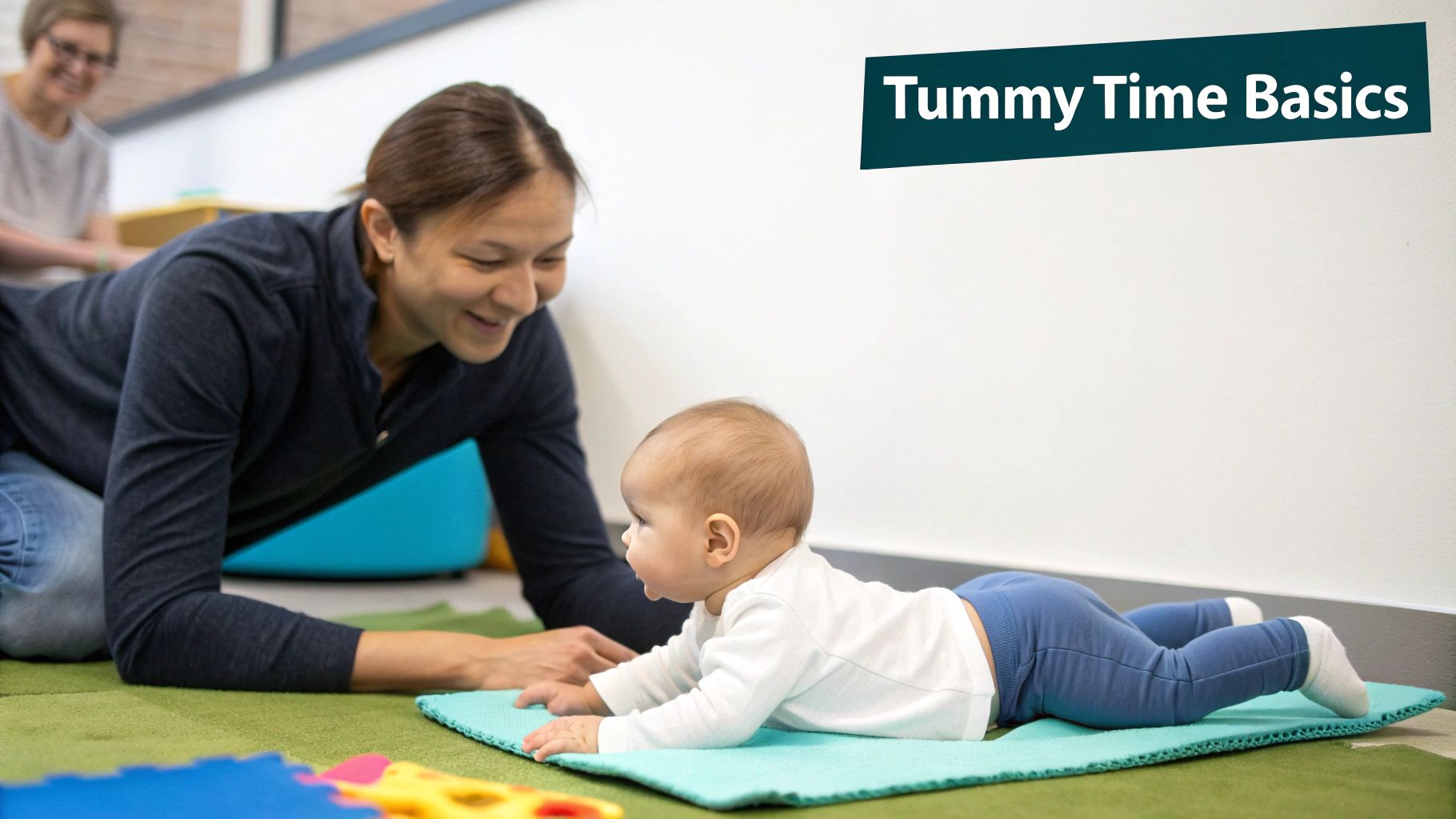 A woman smiles at a baby practicing tummy time on a mat, promoting early development.