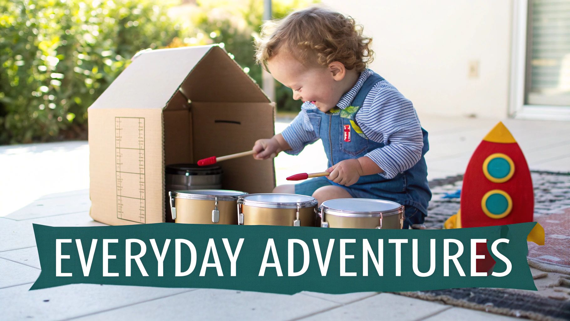 A young toddler inside a large cardboard box, pretending it's a car.