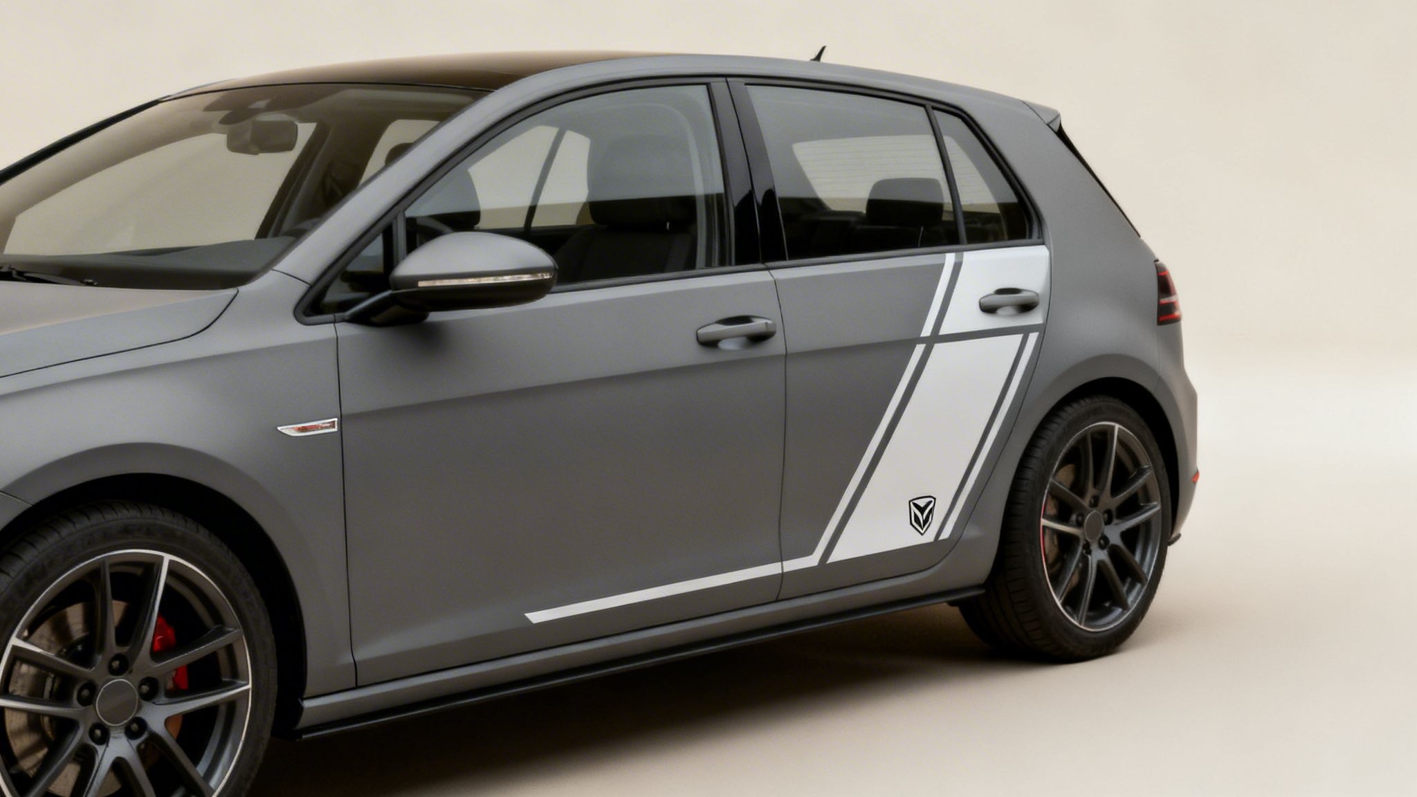 Matte grey Volkswagen Golf-like car with white and grey racing stripe decals and dark wheels.