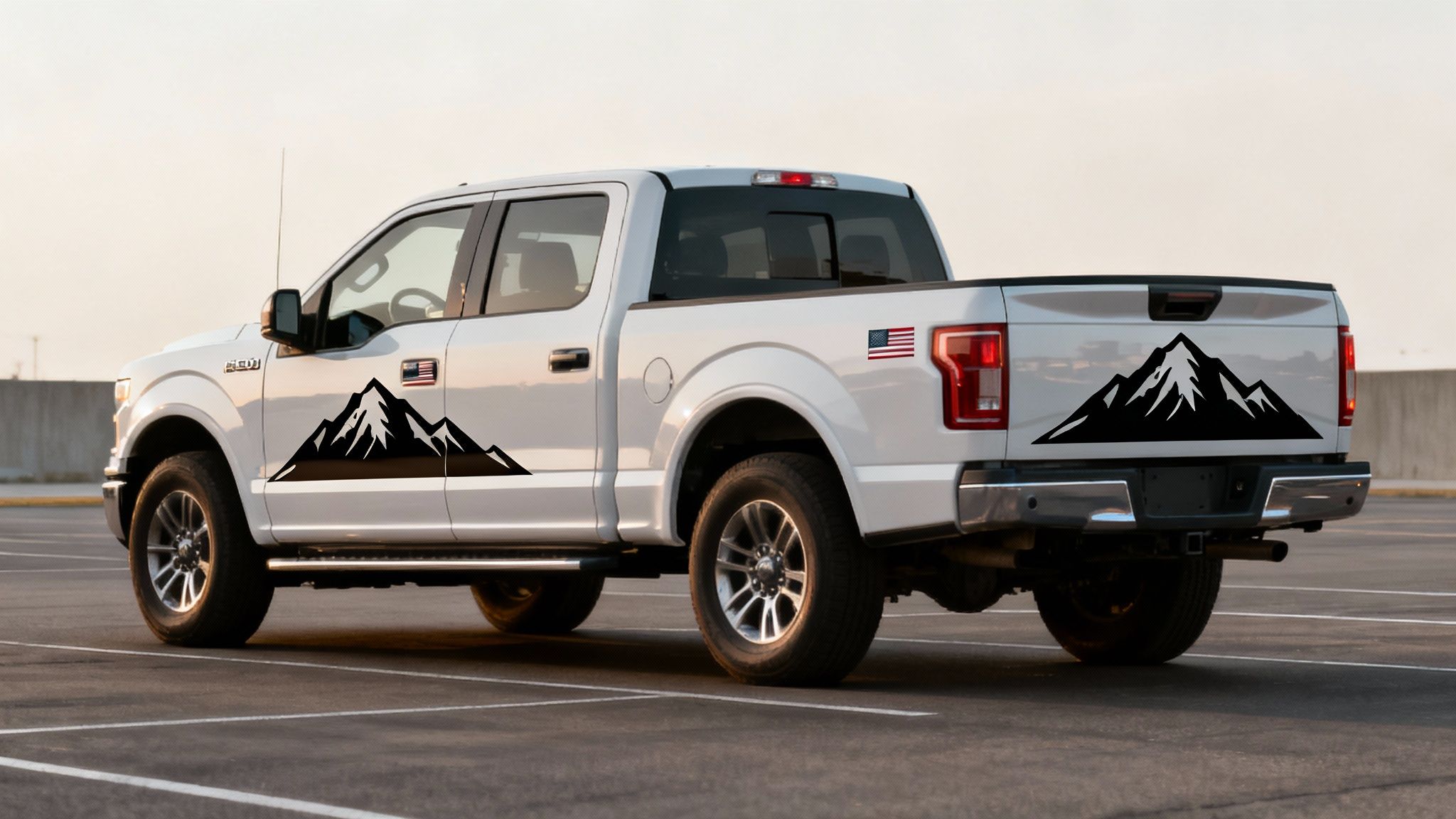 A white Ford F-150 pickup truck with black mountain decals and American flag stickers.