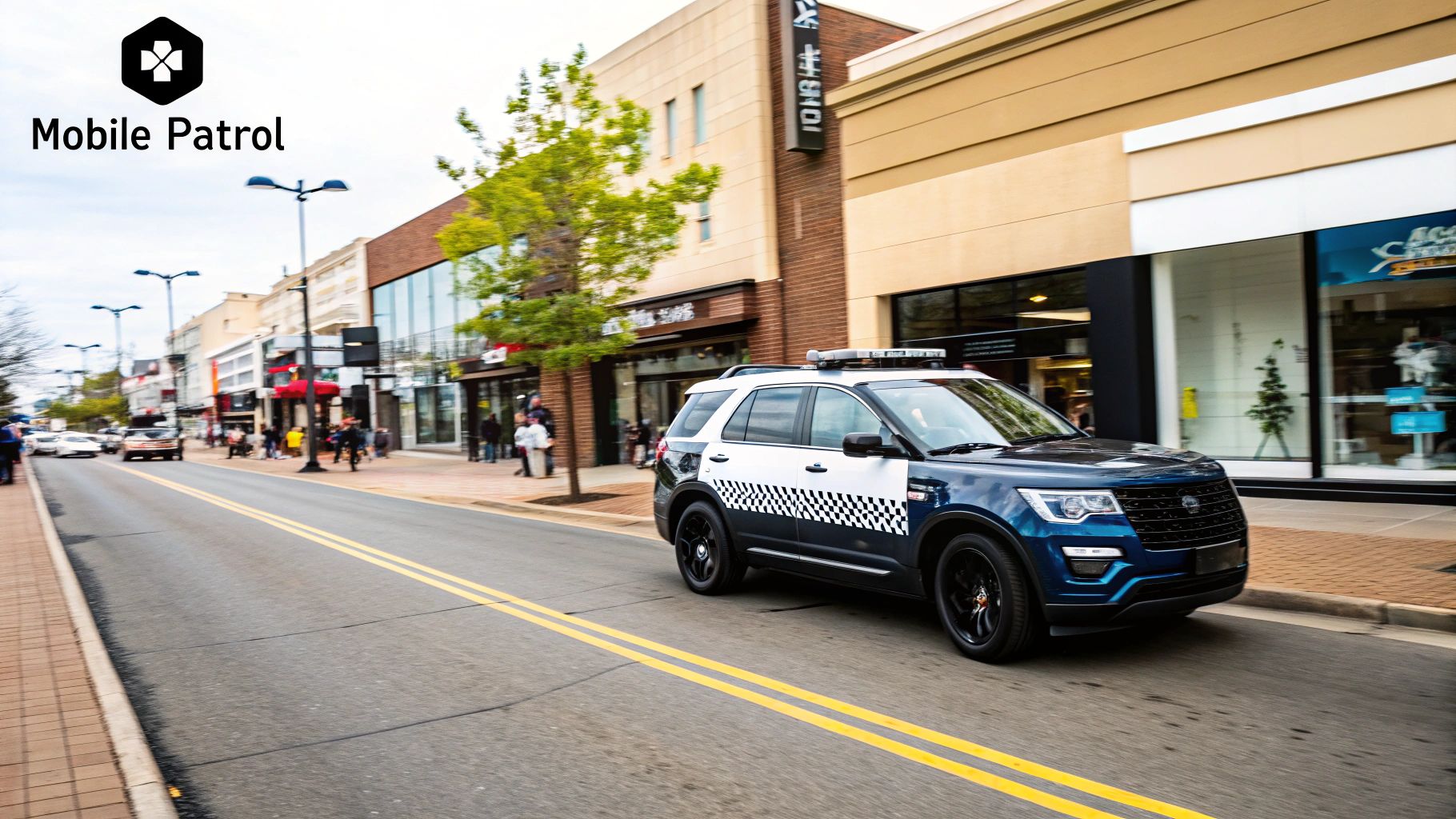 Mobile patrol vehicle driving along a commercial street, emphasizing security presence and deterrence for property protection.