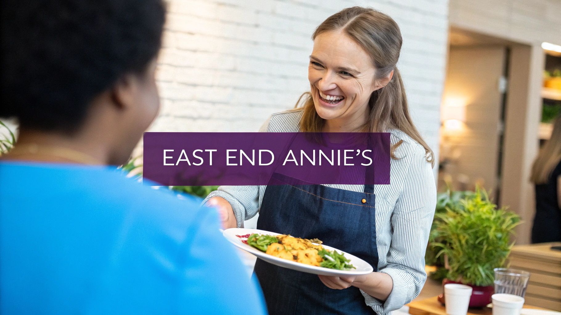 Smiling server at East End Annie's catering presenting fresh meal plate to customer