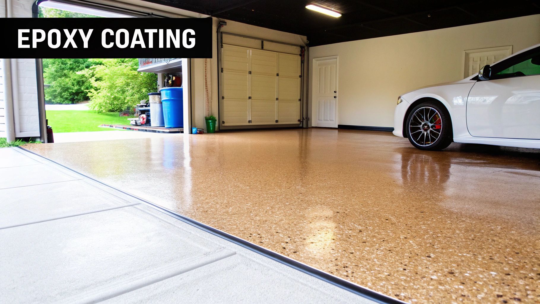 A clean garage featuring a new, shiny, speckled epoxy coating on the floor, with an open door and a white car inside.