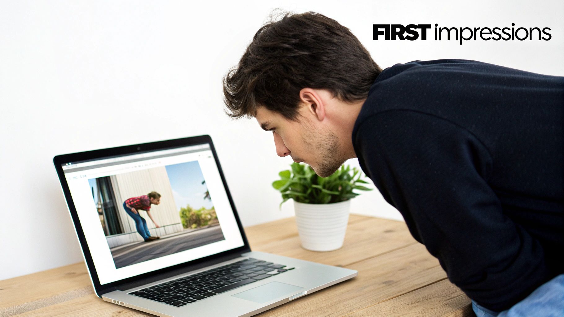 Ein junger Mann betrachtet konzentriert einen Laptopbildschirm, auf dem ein Bild einer Person zu sehen ist, die sich hinunterbeugt.